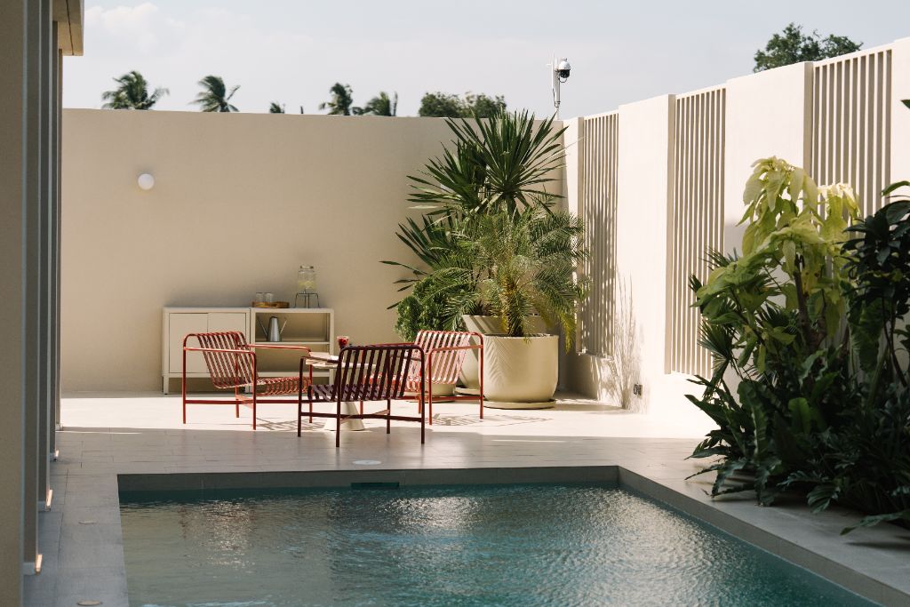 Sunroom pool with red outdoor chairs